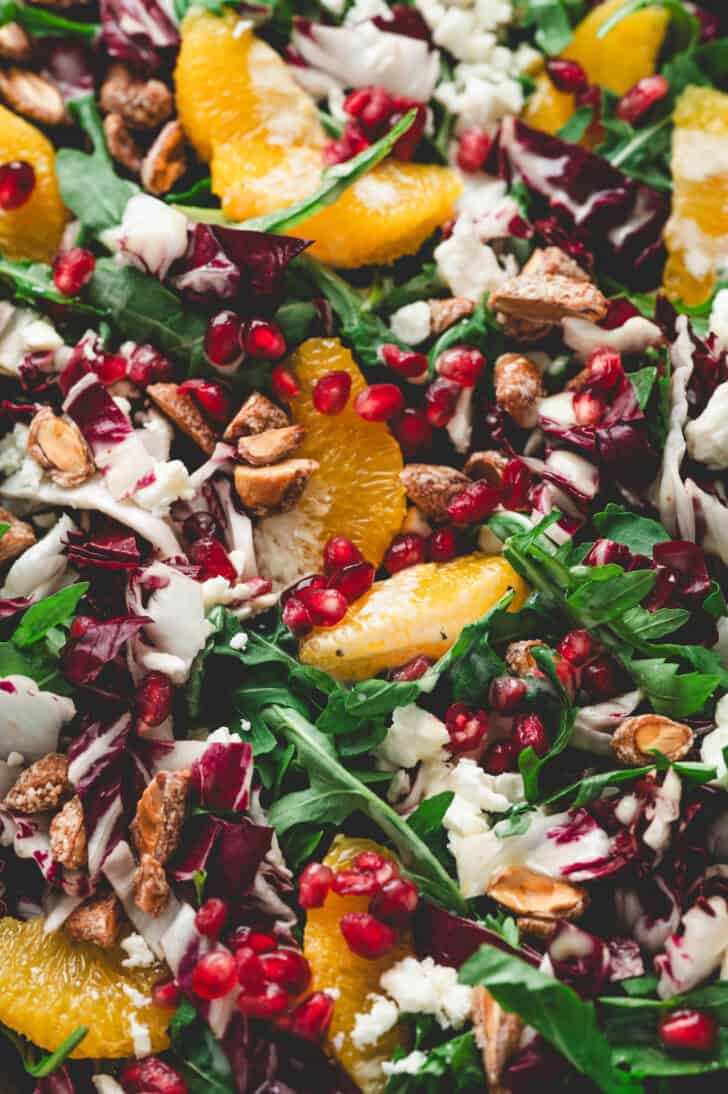 A closeup photo of a Christmas pomegranate salad with oranges and nuts.