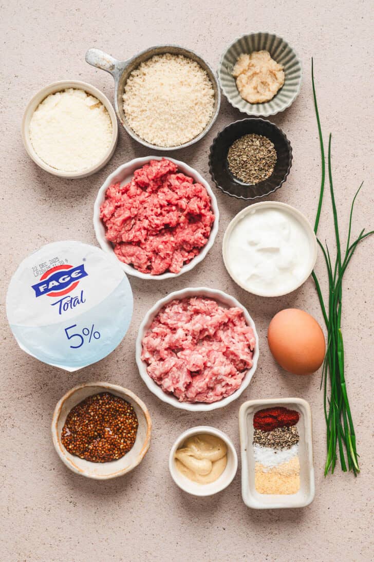 Ingredients on a light background, including ground beef and pork, yogurt, egg and spices.