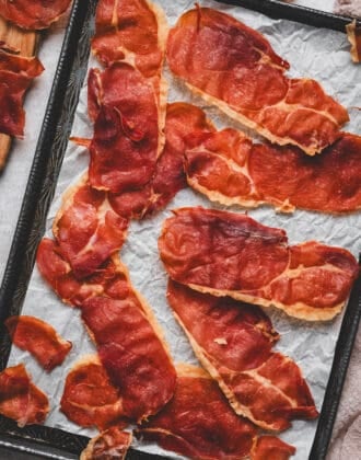 A baking pan covered in crispy prosciutto slices.