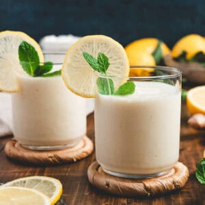 A lemon smoothie garnished with a fresh lemon wheel and mint.