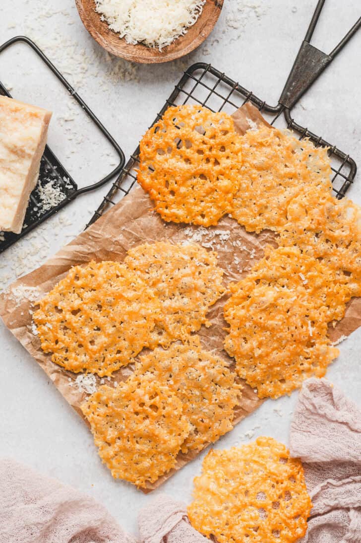 Parmesan crisps on parchment paper on a cooling rack.