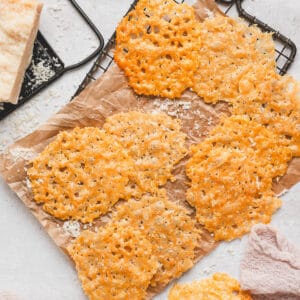 Parmesan crips on parchment paper on a cooling rack.