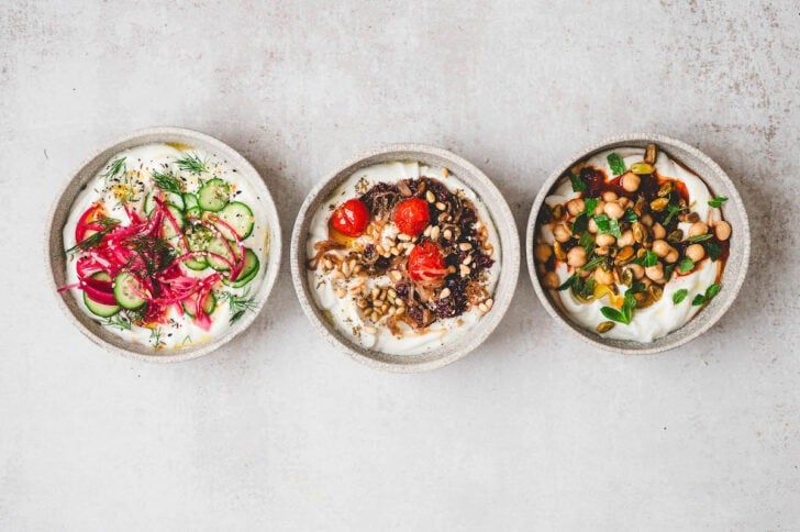Three bowls of savory yogurt recipes on a light background.