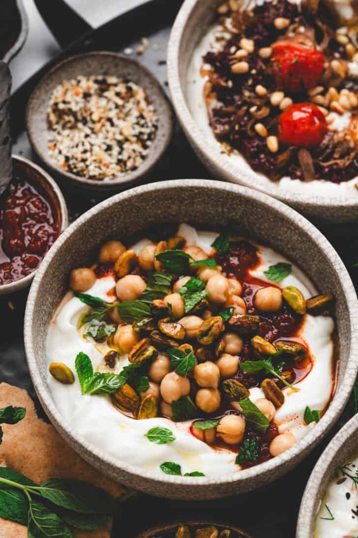 A bowl of savory Greek yogurt topped with harissa, chickpeas and mint.