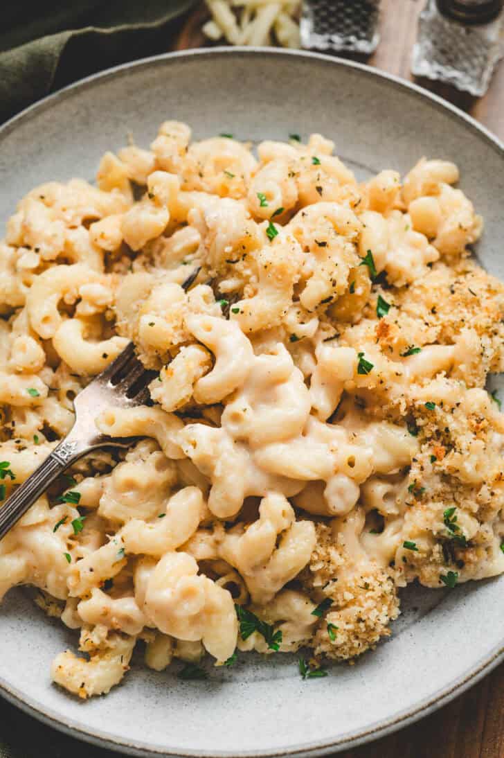 A gray bowl filled with a mac and cheese with beer recipe, with a fork in it.