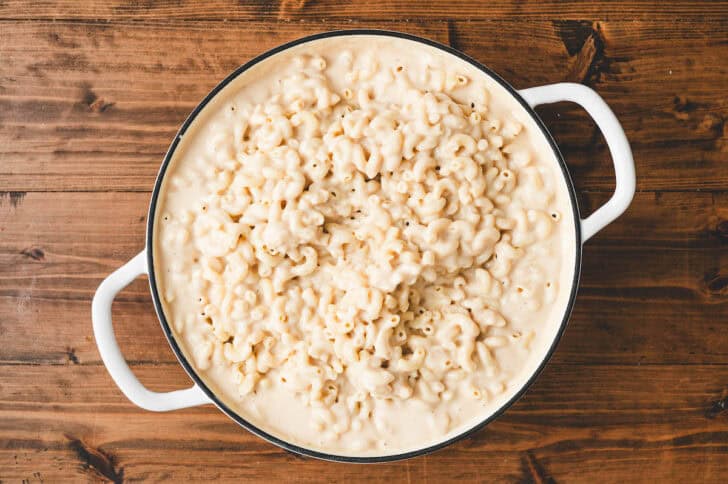 A white pot filled with beer mac and cheese.