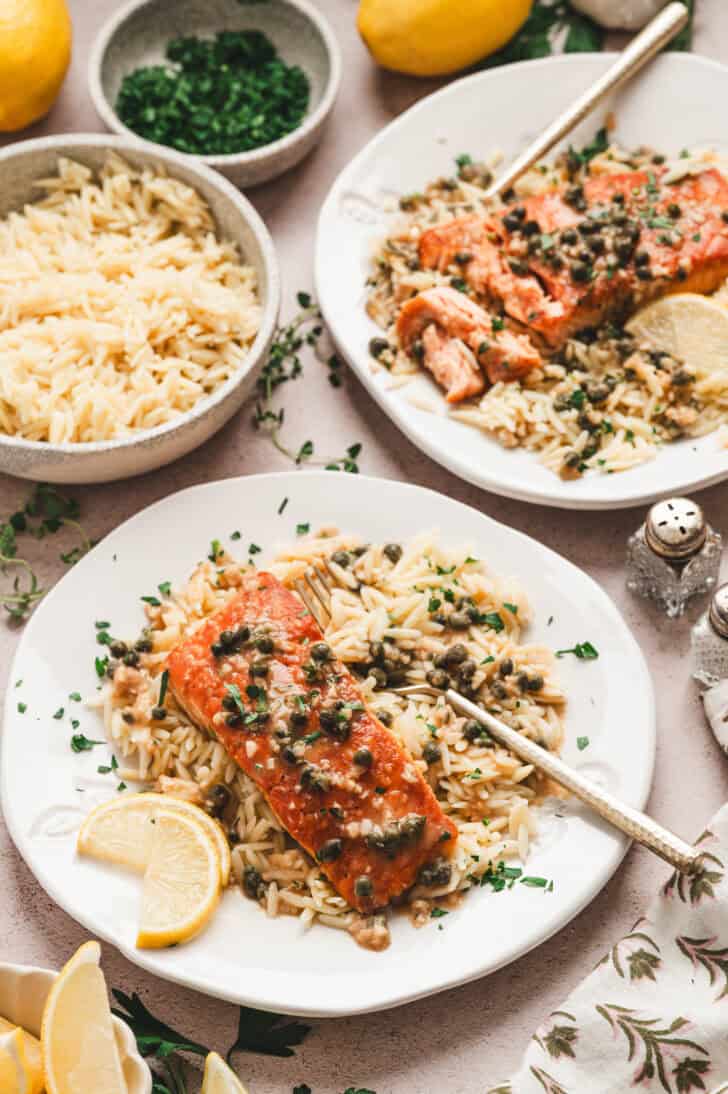 Two plates of a salmon piccata recipe plated with orzo.