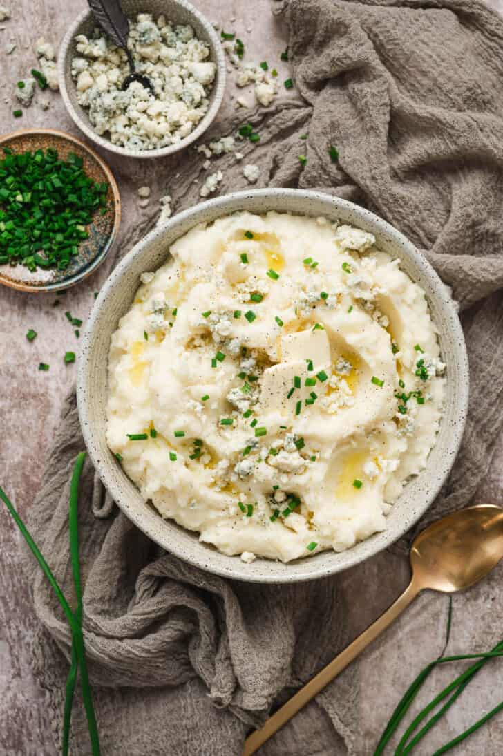 A bowl of blue cheese mashed potatoes garnished with chives.