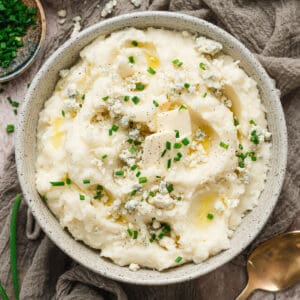A bowl of blue cheese mashed potatoes garnished with chives.