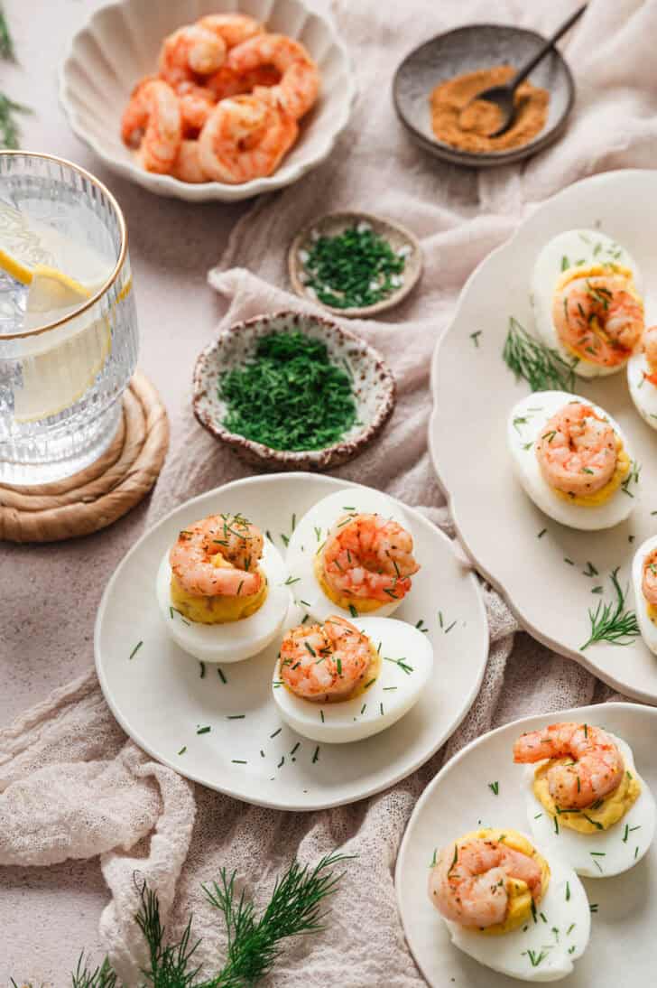 Deviled eggs with shrimp on various serving platters.