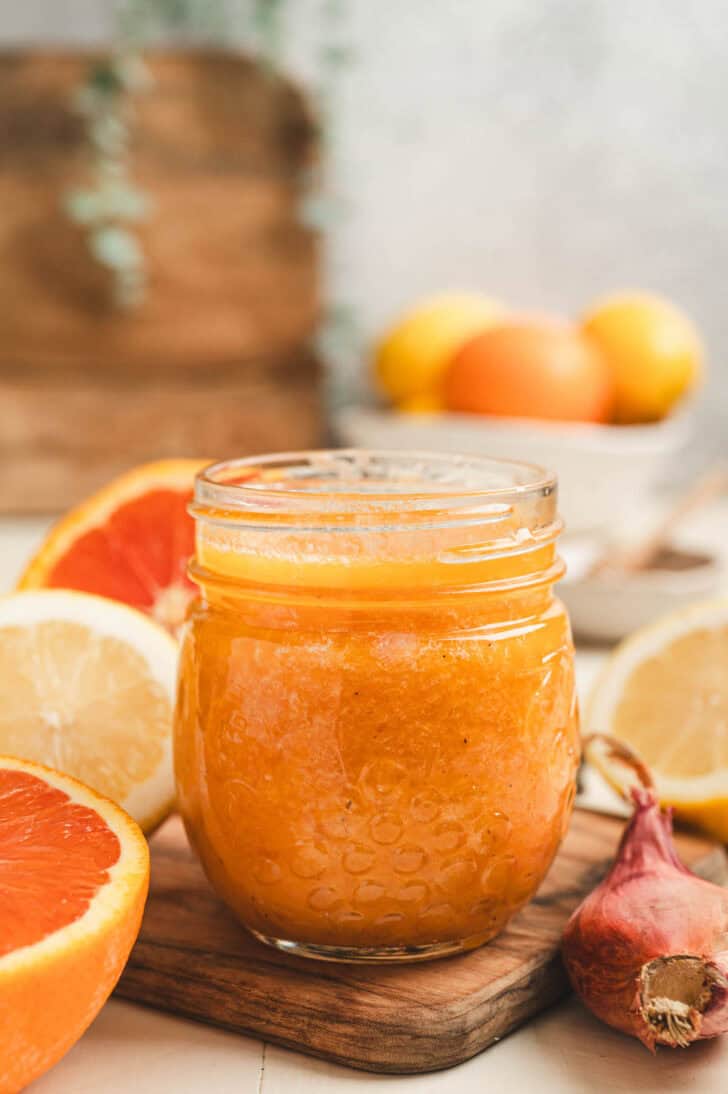 A glass jar filled with a citrus dressing recipe.
