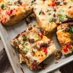 A baking pan filled with cornbread breakfast bake, cut into squares.