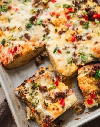 A baking pan filled with cornbread breakfast bake, cut into squares.