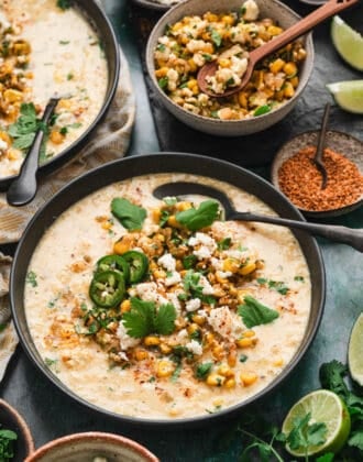 A bowl of Mexican street corn soup with a spoon in it.