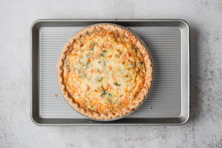 A smoked salmon quiche on a rimmed baking pan.