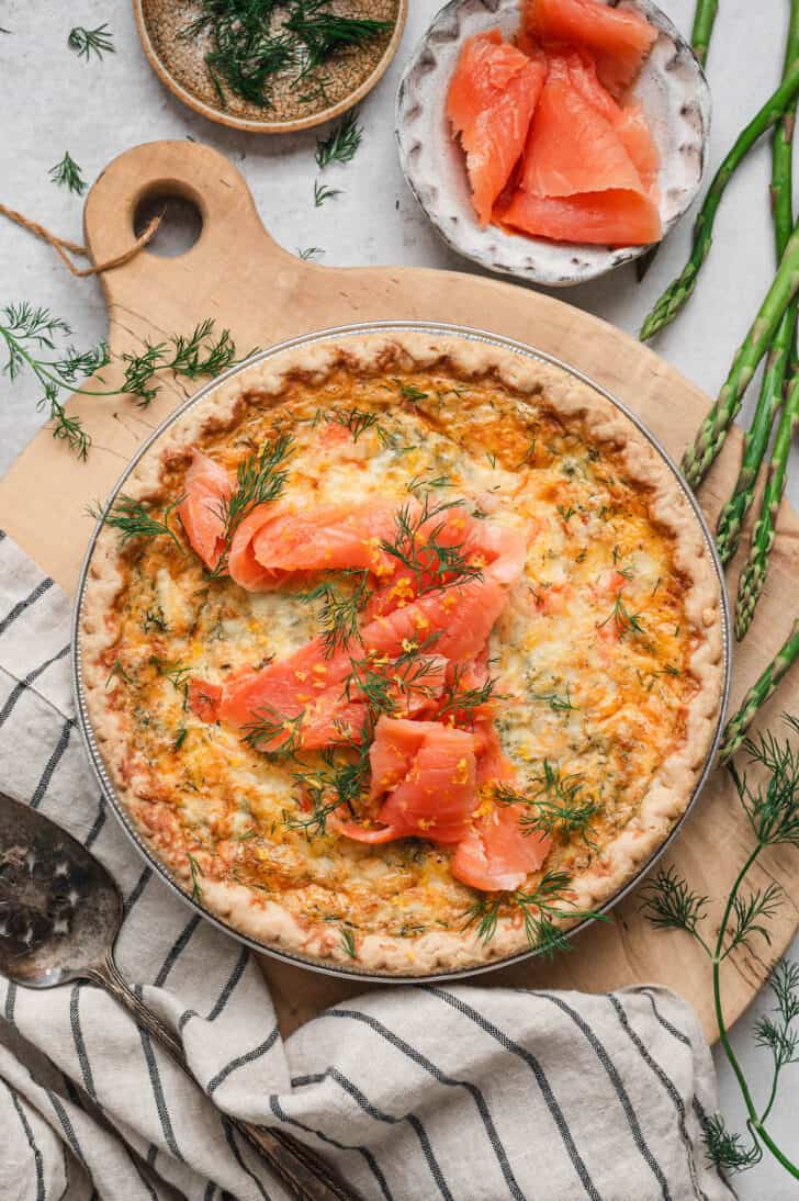 A salmon asparagus quiche on a wooden board.