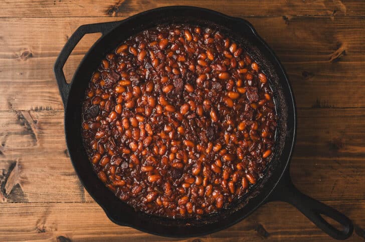 A cast iron skillet filled with Dr. Pepper beans.