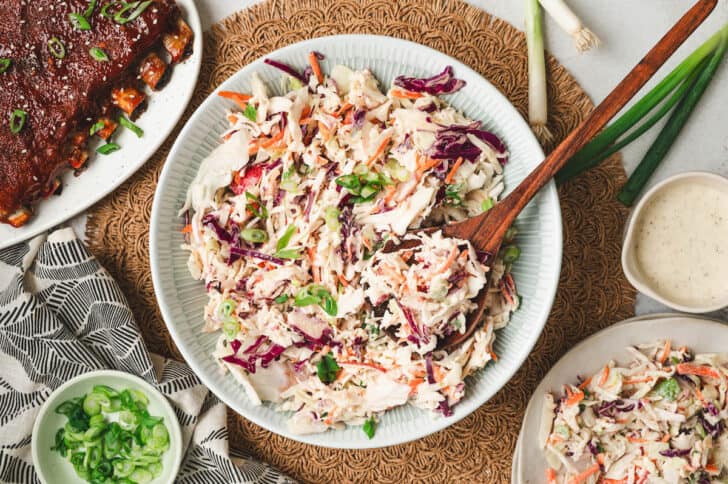 A bowl of apple cider vinegar coleslaw alongside ribs.