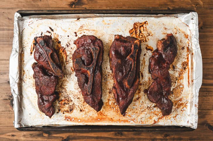 A baking pan filled with country ribs in oven.