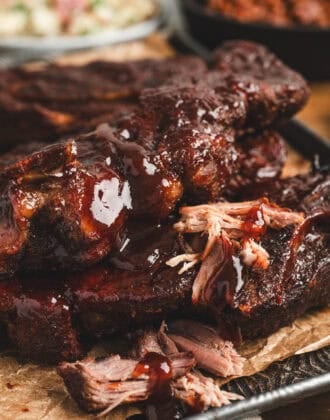 A pile of country style ribs in oven on a baking pan.