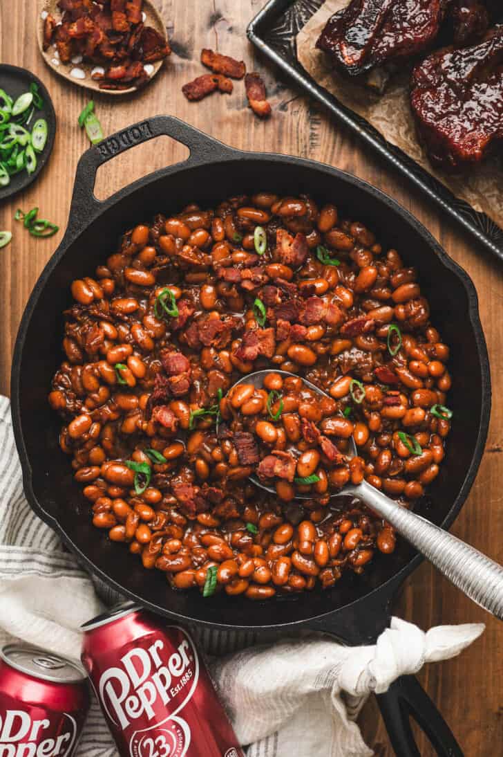 A cast iron skillet filled with Dr. Pepper baked beans