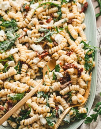 A light blue platter filled with goat cheese pasta salad.