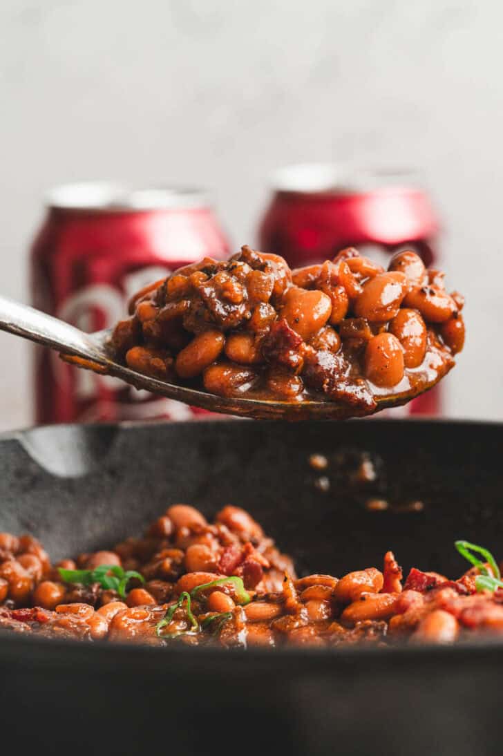 A spoon lifting a scoop of Dr. Pepper beans.