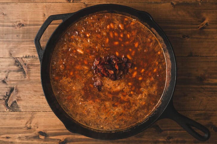 A skillet filled with a baked beans with bacon recipe.