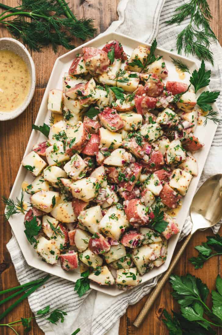 A no mayo potato salad recipe on a white platter.