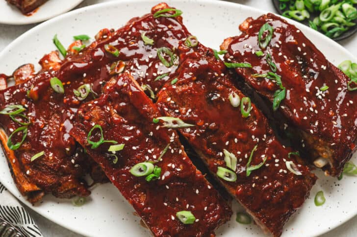 Asian spare ribs on a white platter.