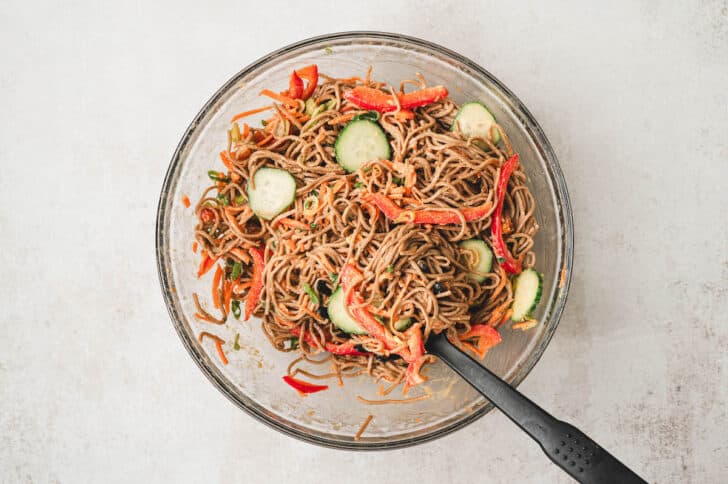 A glass bowl filled with cold Asian noodle salad.