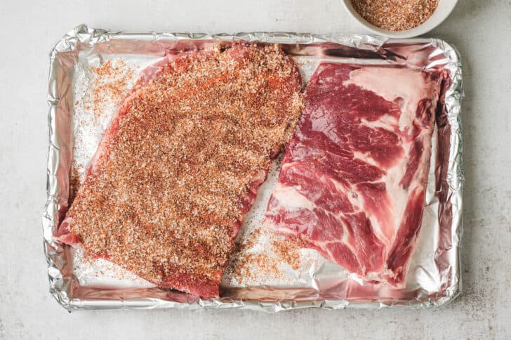 Spare ribs being rubbed with a spice blend.