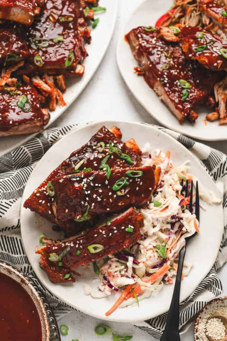 A plate filled with Asian Style Pork Ribs and coleslaw.