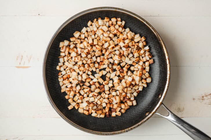 Hash browns being cooked in a skillet.