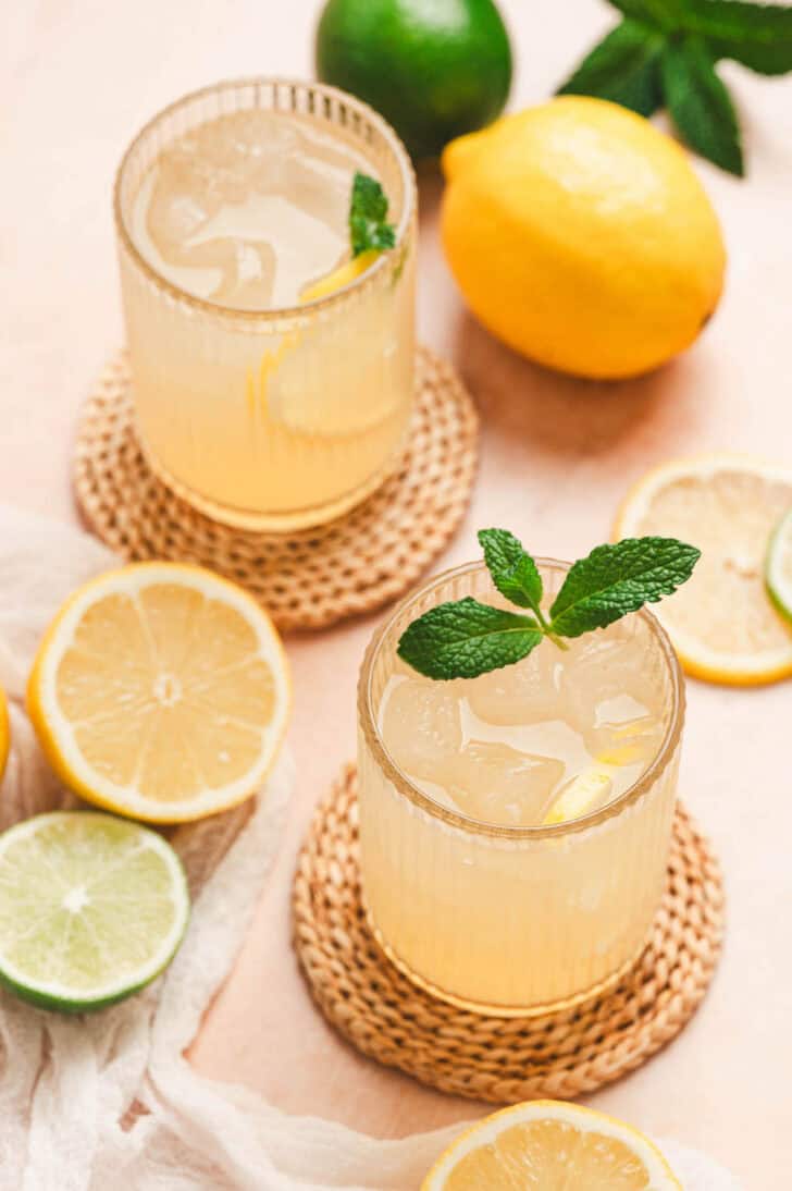 Glasses filled with an agave lemonade recipe on bamboo coasters.