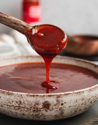 A spoon drizzling Asian BBQ sauce into a bowl.
