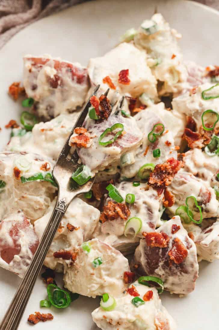 Closeup photo of a potato salad recipe with bacon crumbled over it.
