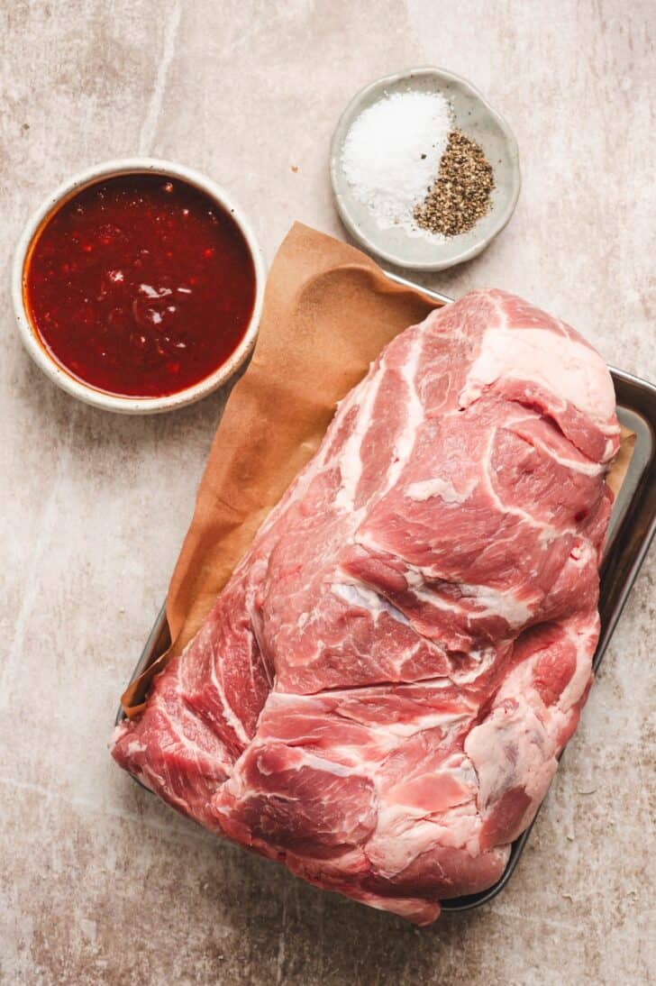 Boneless pork shoulder with Asian BBQ sauce, kosher salt and black pepper for slow cooker Asian pork