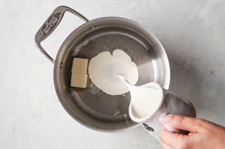 Butter and heavy cream being warmed together in a saucepan